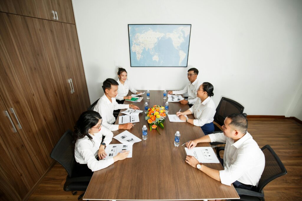 Group of professionals having a strategic business meeting at a conference table in a modern office setting.