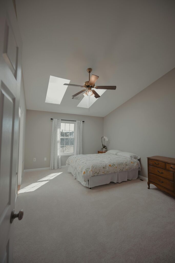 A clean and cozy bedroom with skylights, offering natural light and a minimalist design.